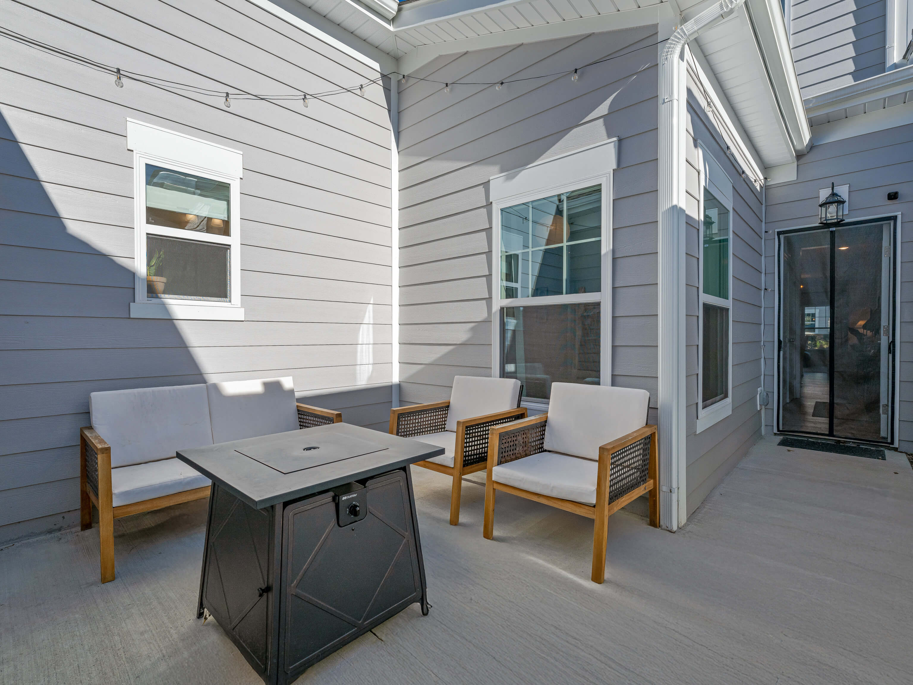 Covered outdoor patio with dining furniture and string lights