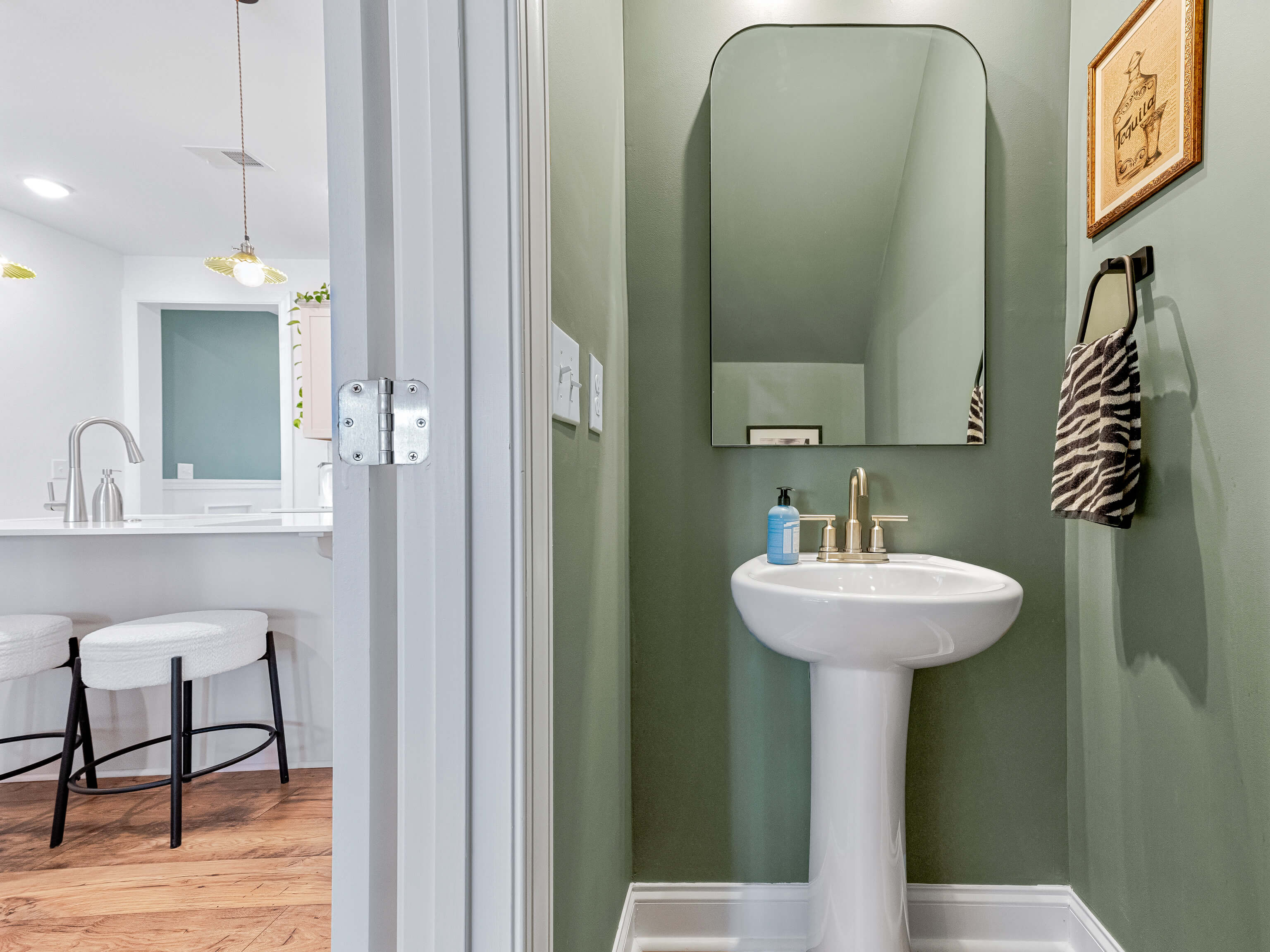 Powder room with sage green accent wall and pedestal sink